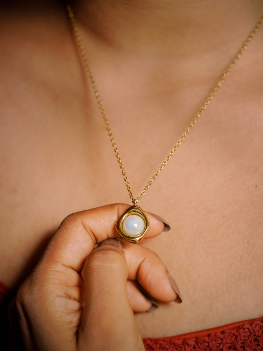 Ashborne Hansika freeform bezel cabochon pendant held at the collarbone