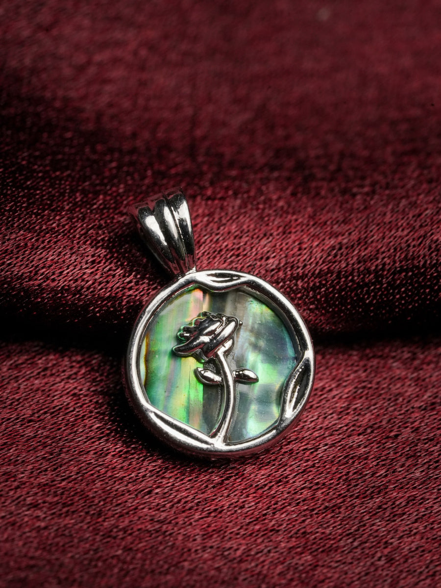 Ashborne Renu silver rose pendant over green-blue abalone shell background