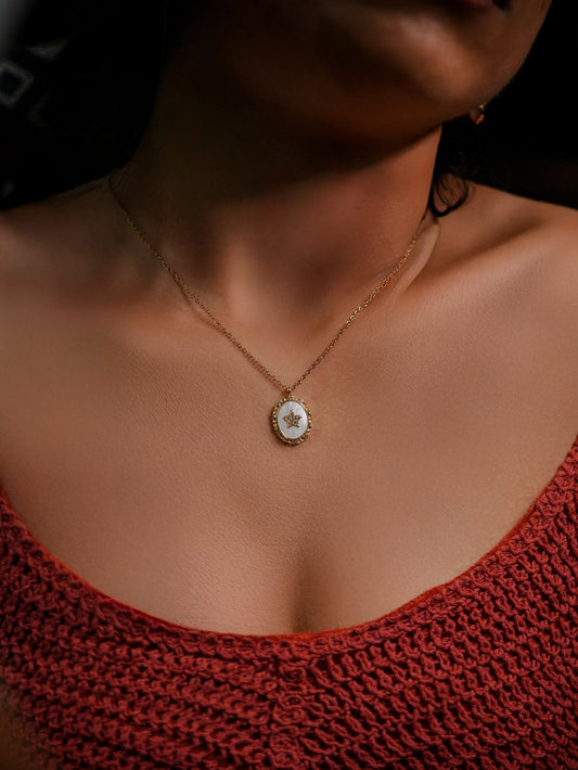Ashborne Kavya oval mother-of-pearl pendant with beaded rim and crystal star, worn on model