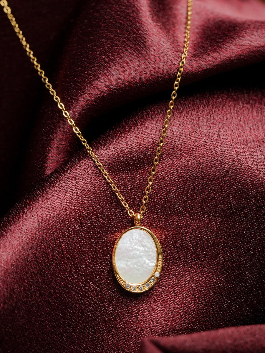 Ashborne Nandini oval mother-of-pearl pendant with crystal cluster on fine chain, on satin