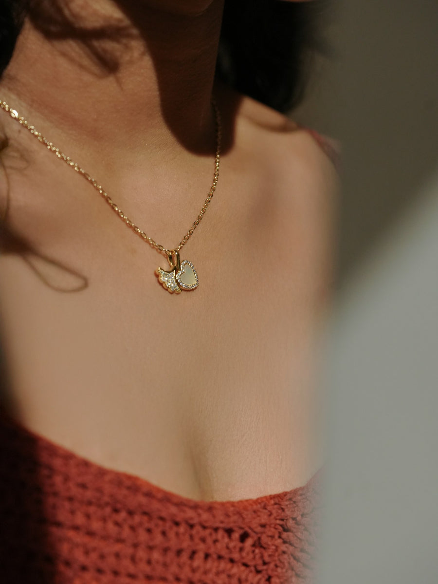 Ashborne Kimaya crystal butterfly and mother-of-pearl heart cluster pendant worn on model