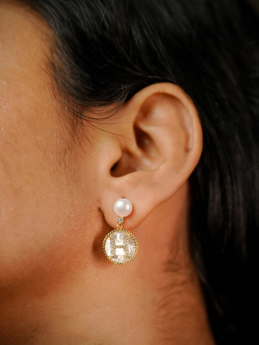Ashborne Ishita pearl-top H initial drop earring worn on ear