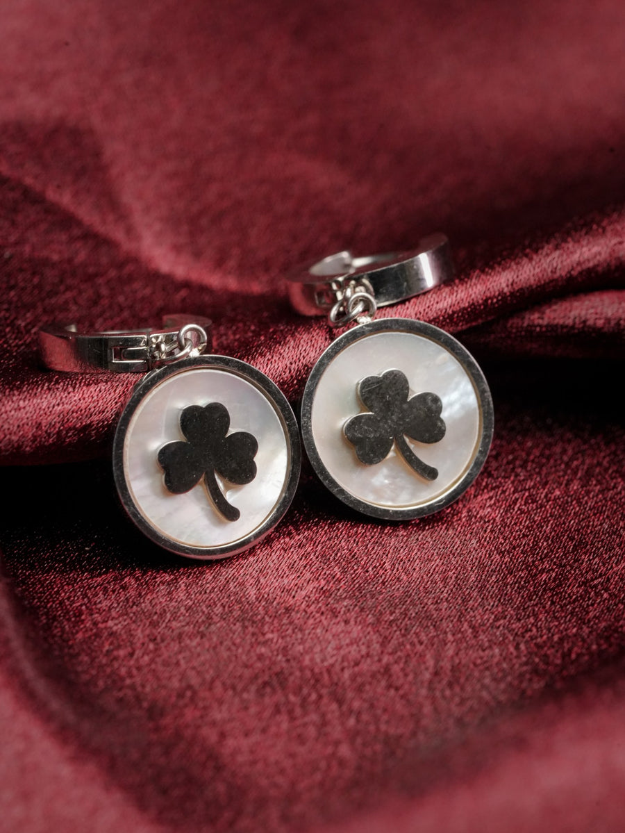 Pair of silver-tone huggie earrings with mother-of-pearl clover charm discs