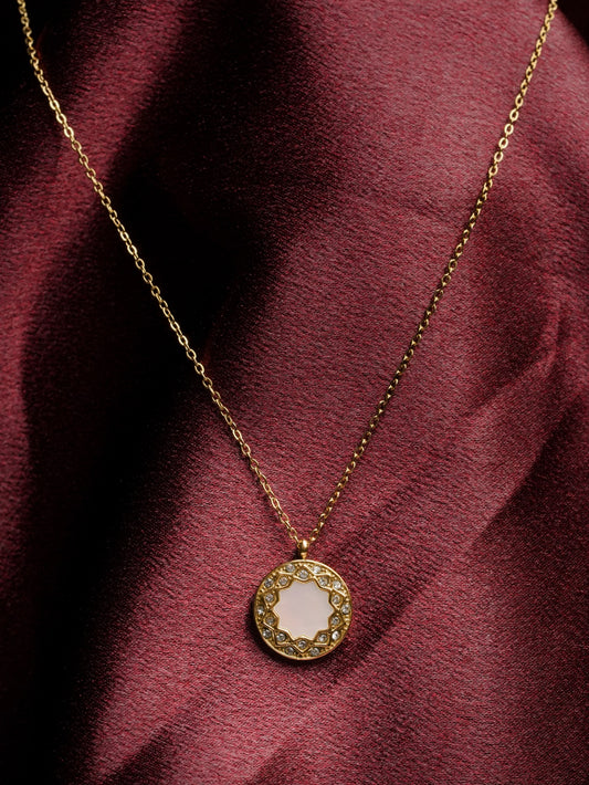 Ashborne Pari sunburst mother-of-pearl medallion necklace worn on maroon satin