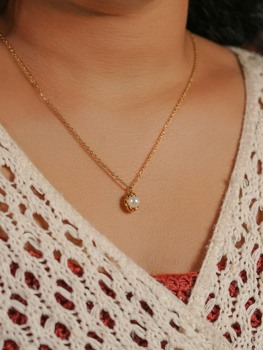 Ashborne Mala caged pearl pendant on a fine gold-tone chain worn at the throat