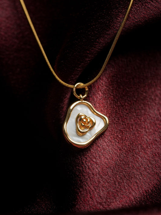 Ashborne Neha freeform mother-of-pearl pendant with gold rose centre on snake chain, closeup